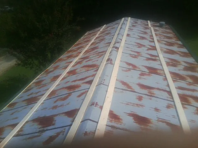 Rusted metal roof panels with new wood purlins before replacement — Storm Damage Roof Repair in Gower by Roofing Brothers