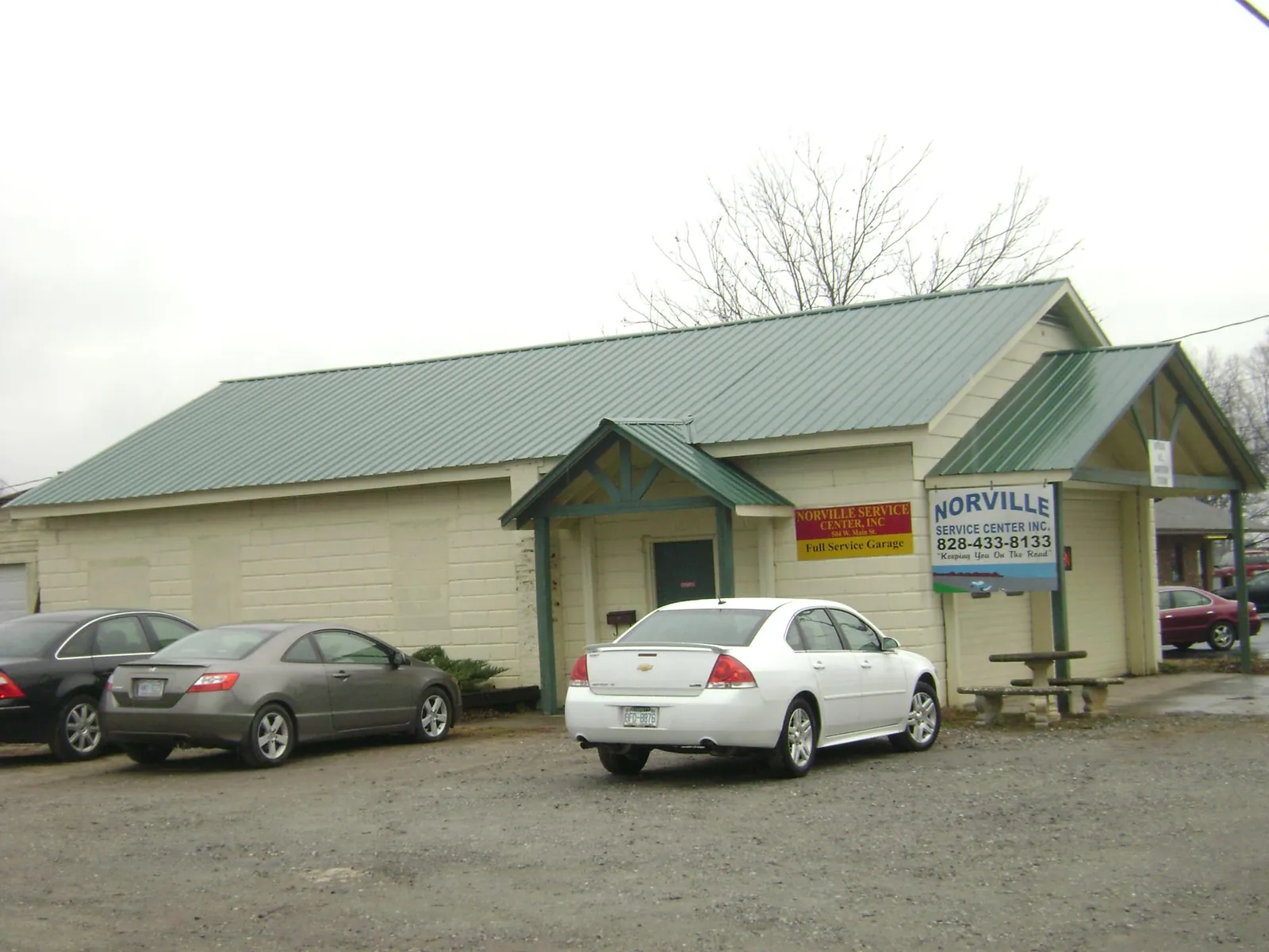 Green metal roof on a service garage with a covered entry in Gower