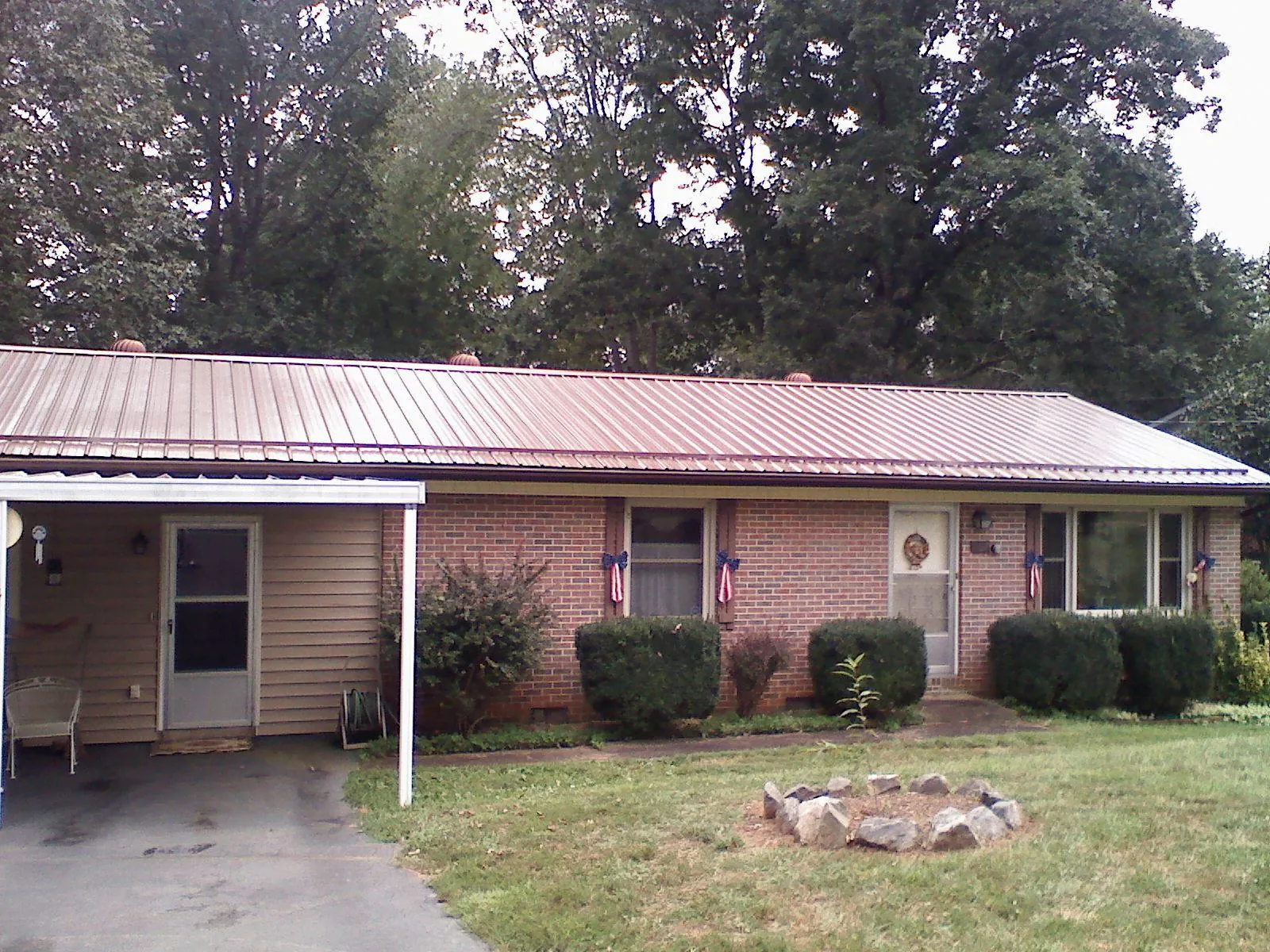 Bronze metal roof and carport on a brick ranch home — Roof Repair work by our crew in Gower