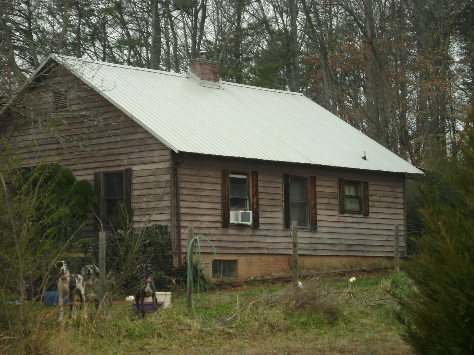 White metal roof on an old wood sided farmhouse, from a Metal Roof Installation job in Gower